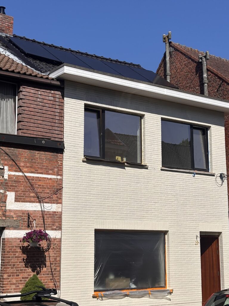 Lichte, vernieuwde gevel van een rijwoning met nieuwe ramen en een donker dak