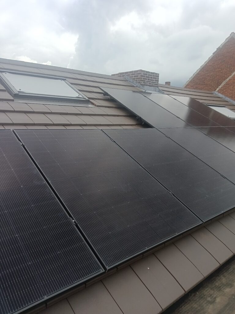 Zwarte zonnepanelen op een bruin pannendak met een dakvenster